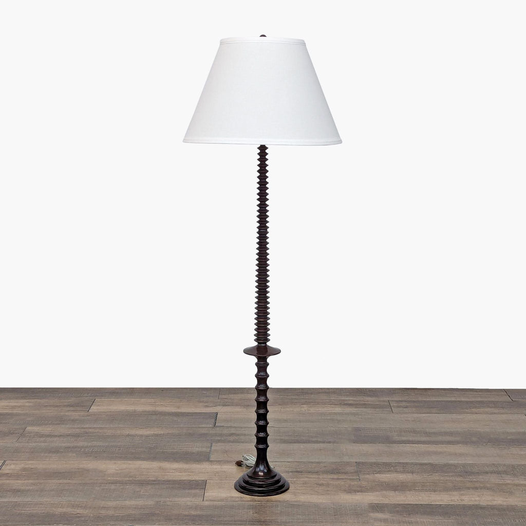 a black and white floor lamp with a white shade.