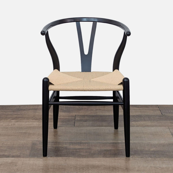 a black and white dining chair with a beige cushion.