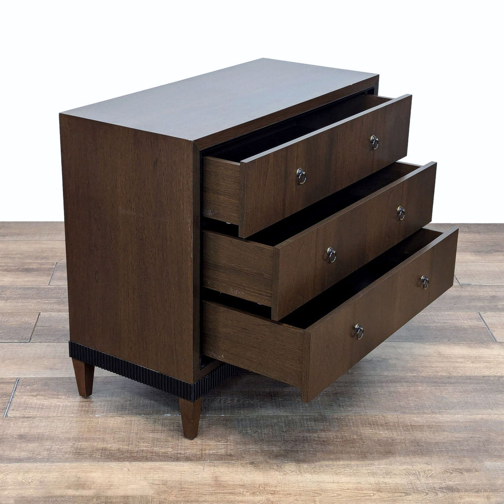 the three drawer chest is made of dark brown wood with a metal base.