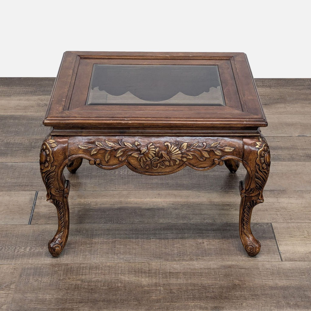 a 19th century french carved wood table with a glass top.