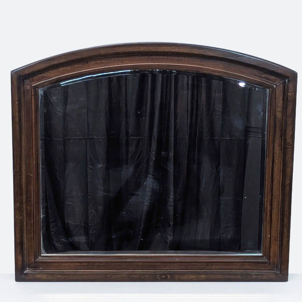 a large, antique, victorian style mirror with a black curtain panel.