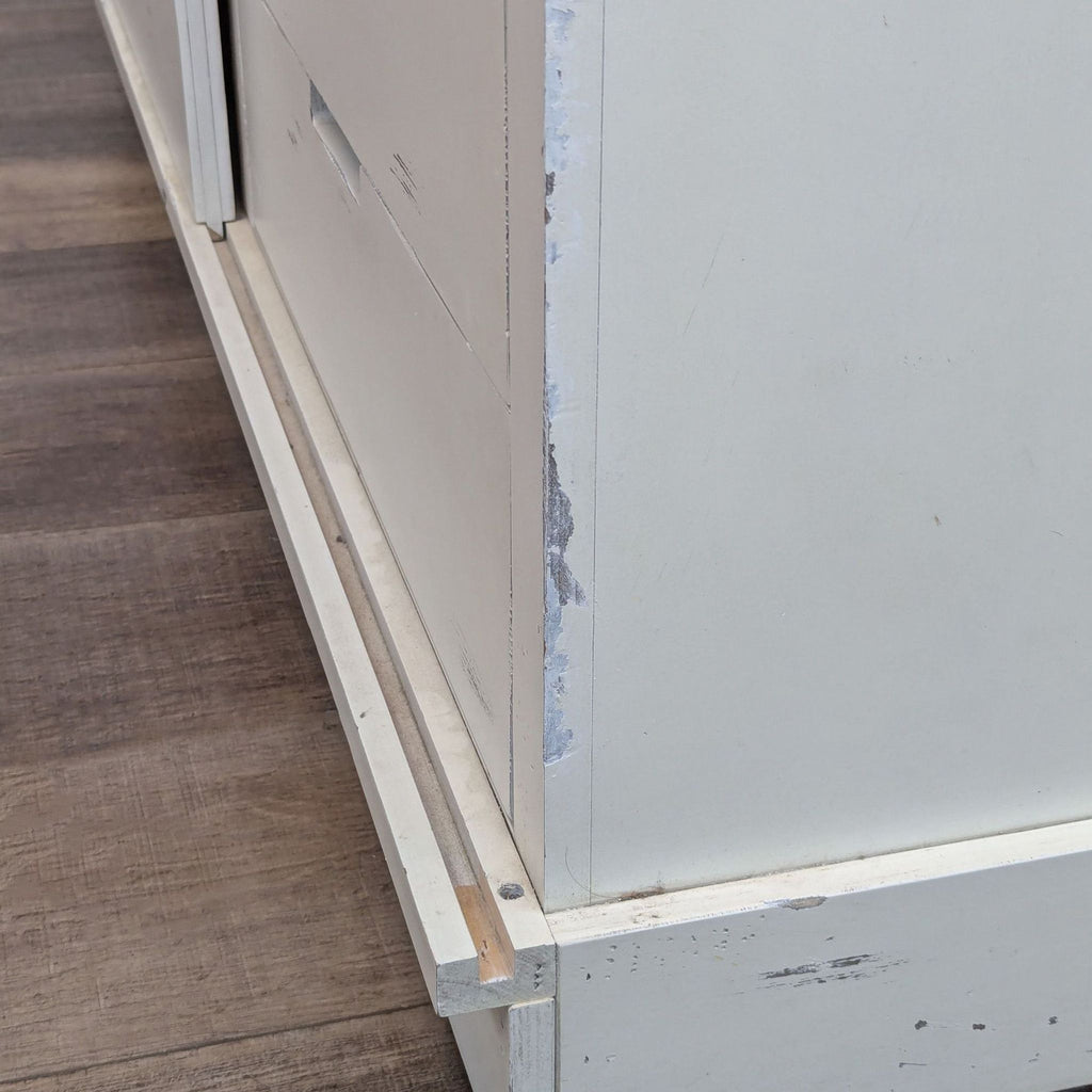 a close up of the front of a white wooden dresser.