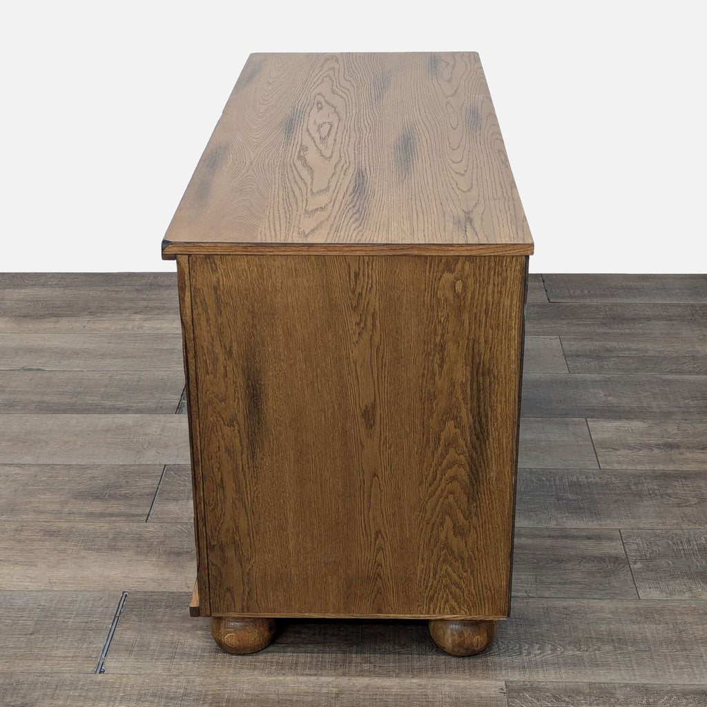 a small, rectangular, solid wood side table with a round top.