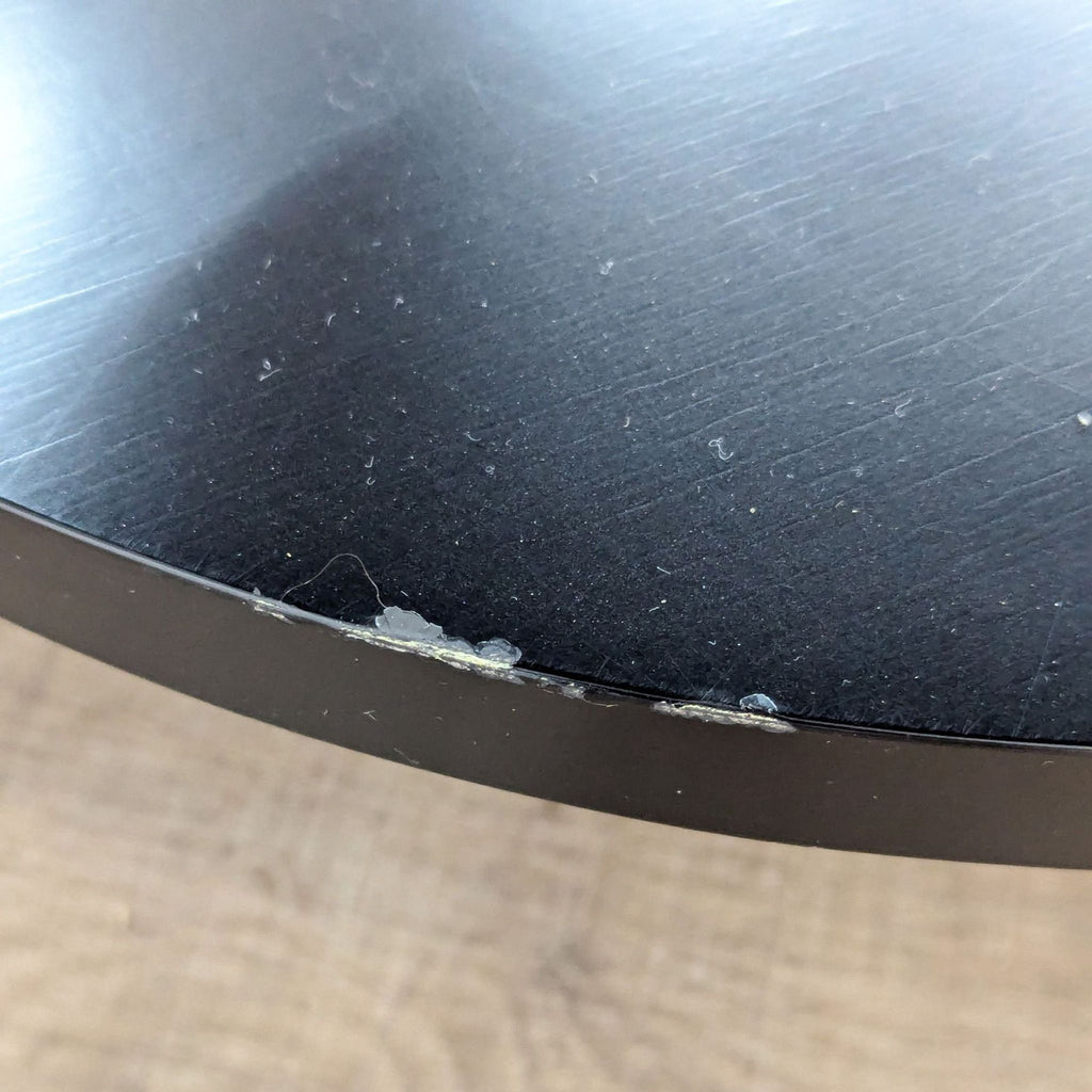 a black metal table top with a black metal base.