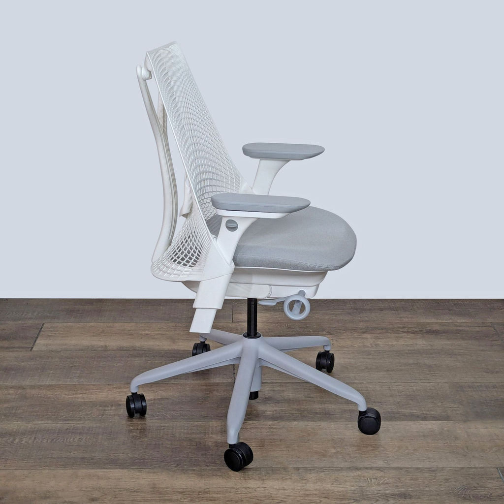 a white mesh office chair with a white back and arms.