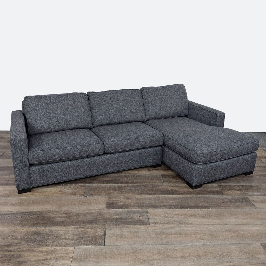 Gray sectional by Reperch with chaise, sleek design, black wood feet.