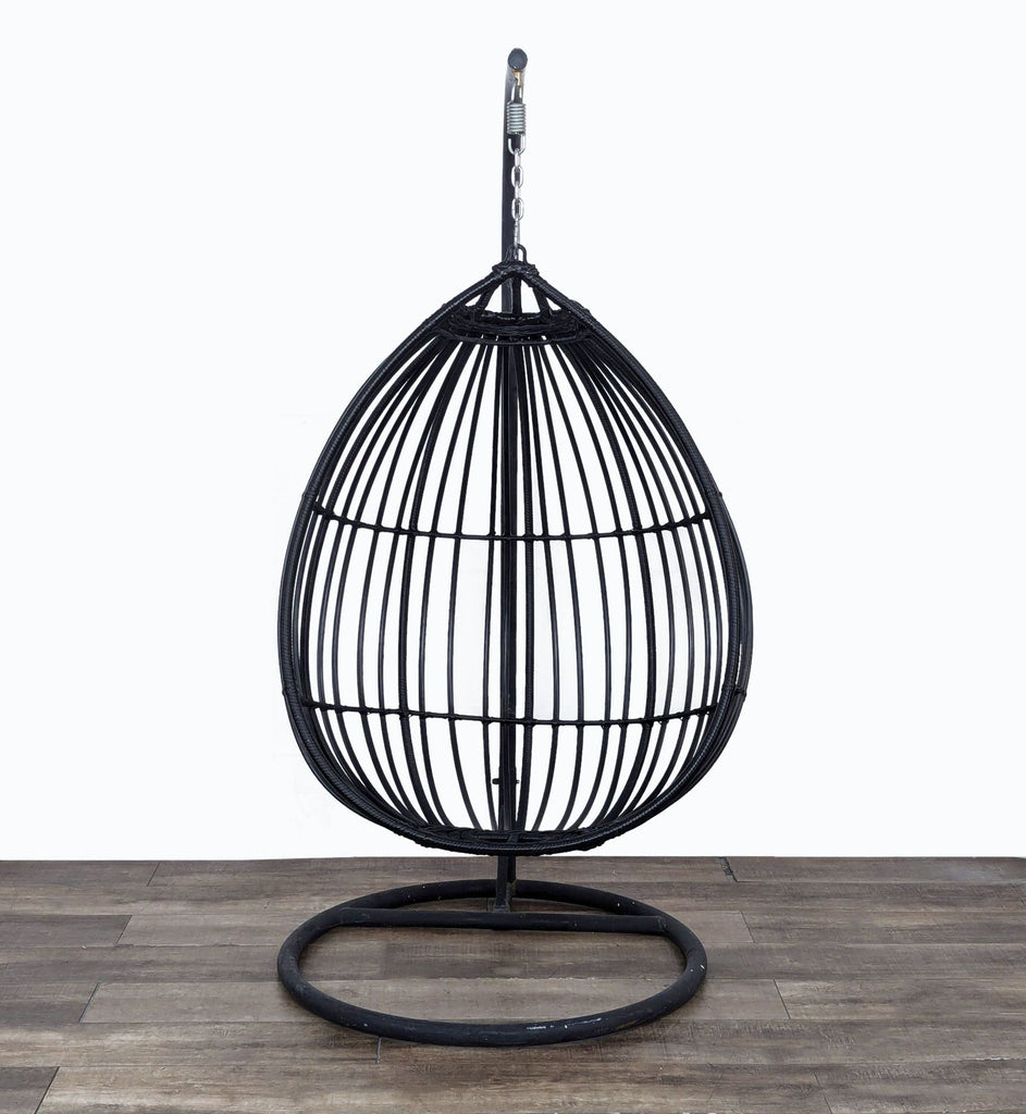 a black birdcage with a metal base and a metal cage.