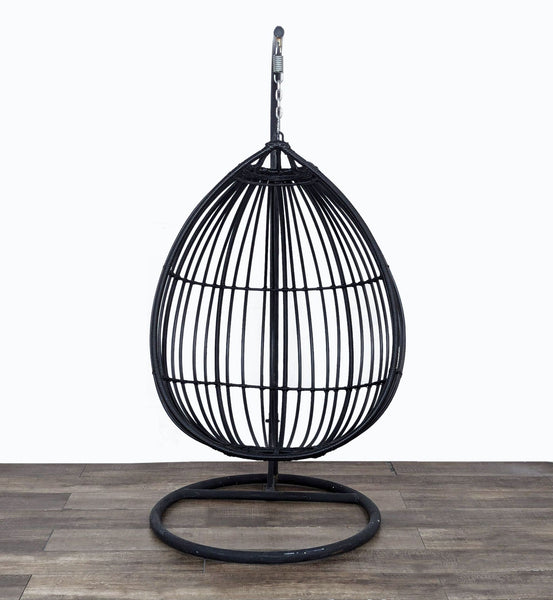 a black birdcage with a metal base and a metal cage.