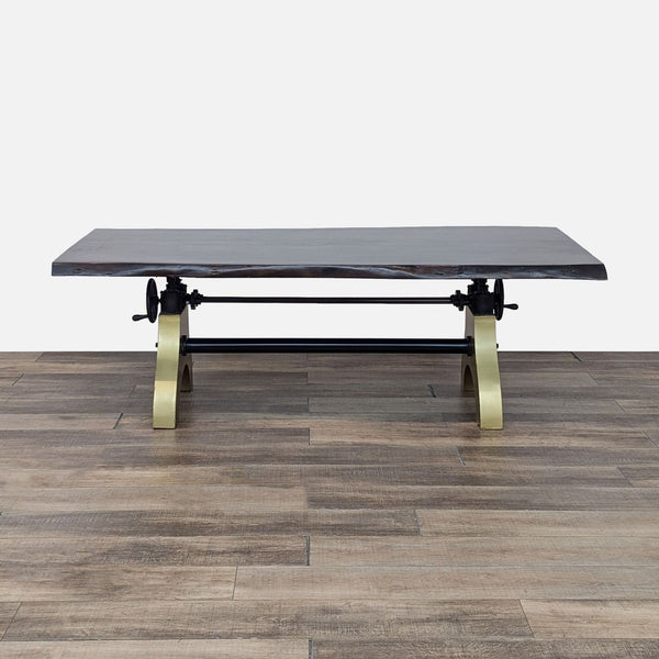 a coffee table with a black leather top and brass legs.