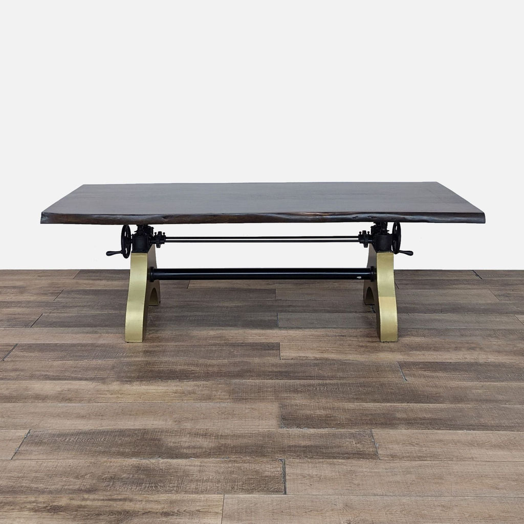 a coffee table with a black leather top and brass legs.