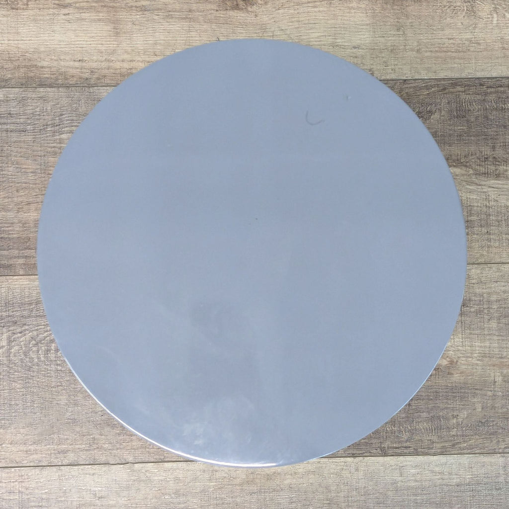 a round metal table top with a metal base.