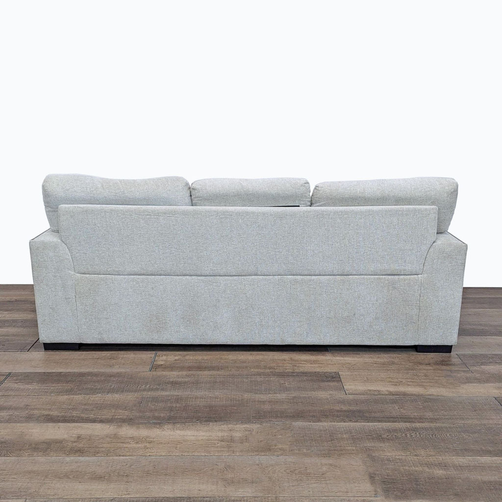 a white couch sitting on top of a wooden floor 