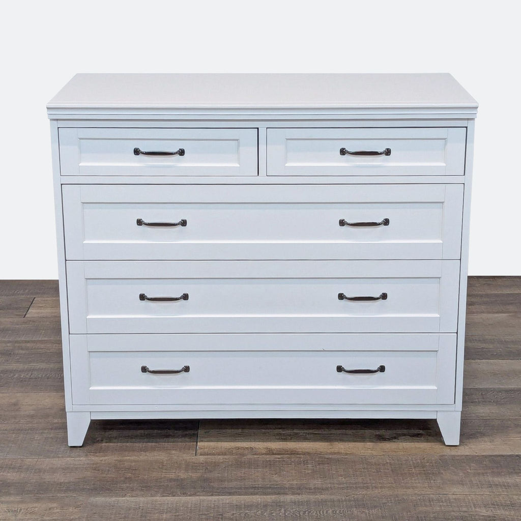 a white and black dresser with a black handle 