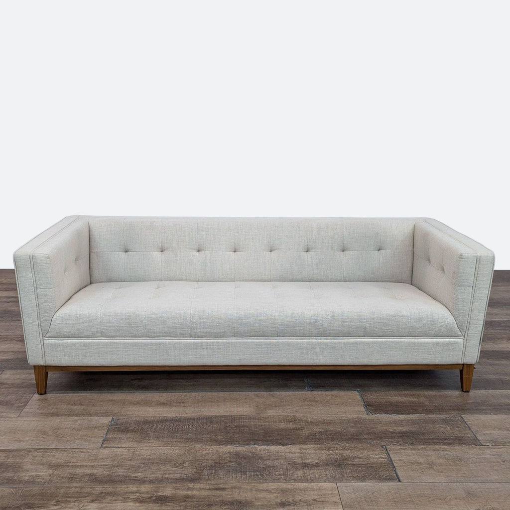 a white couch sitting on top of a wooden floor 