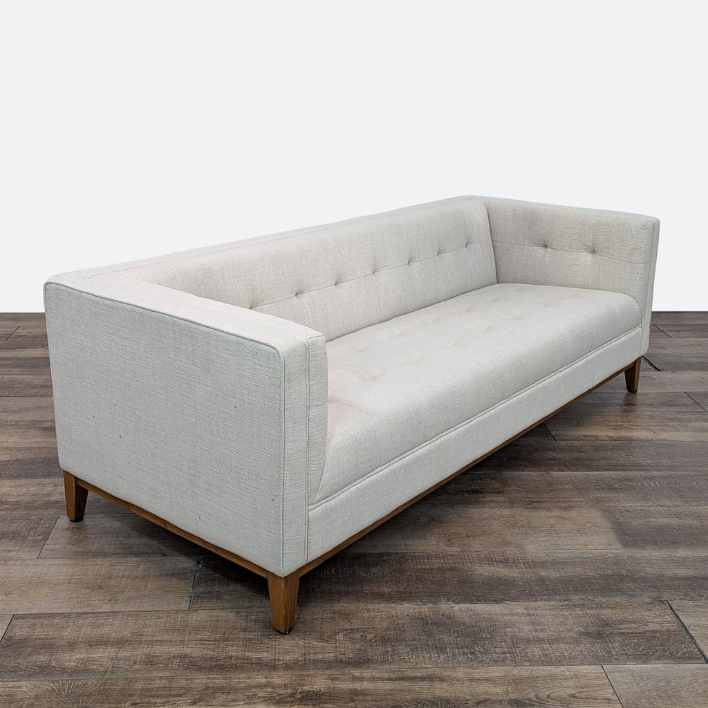 a white couch sitting on top of a wooden floor 