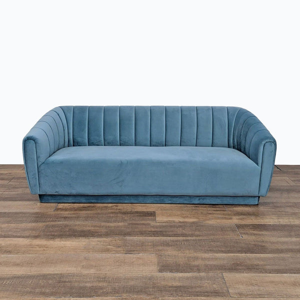 a blue couch sitting on top of a wooden floor 