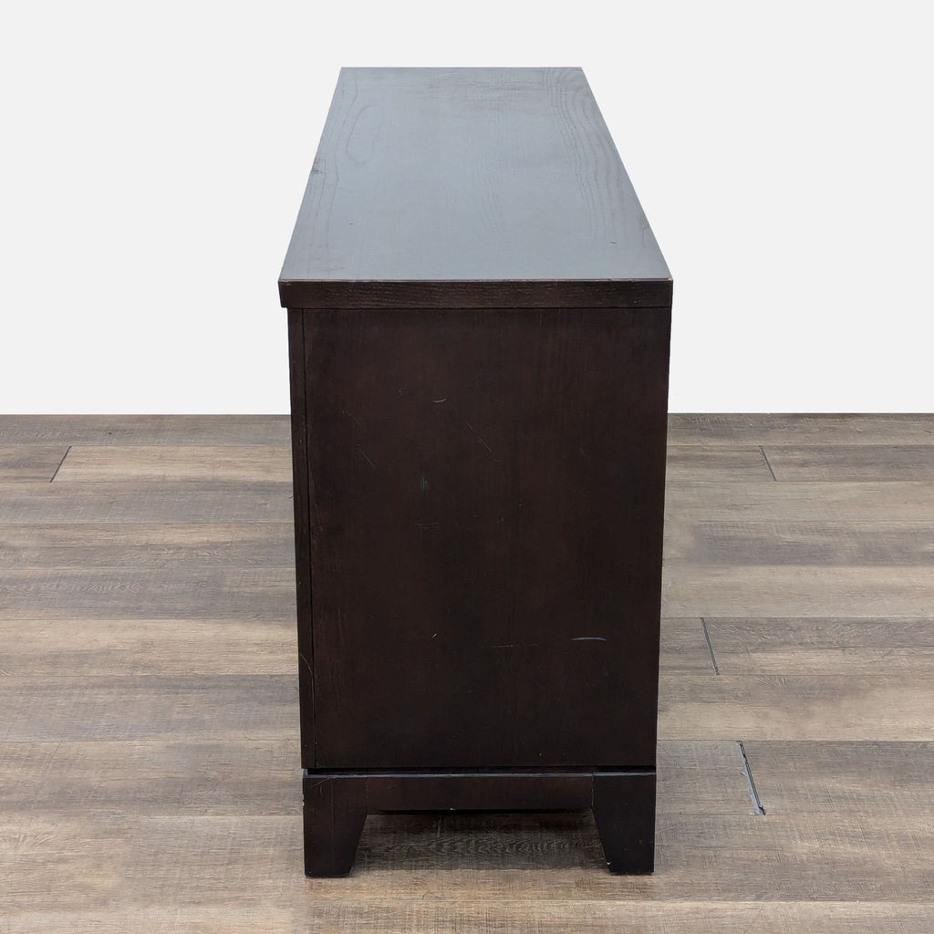 a wooden table with a black and white vase on top 