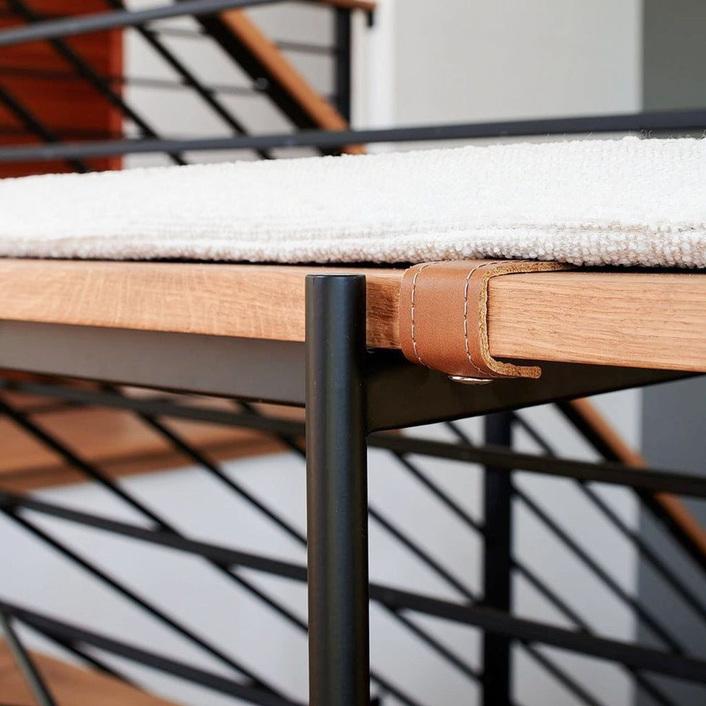 a wooden bench is on a ledge near a building 