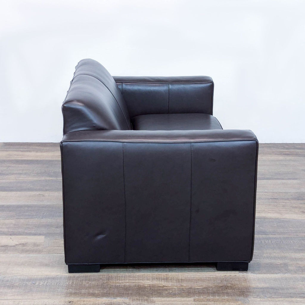 a black leather chair with a black leather cushion 