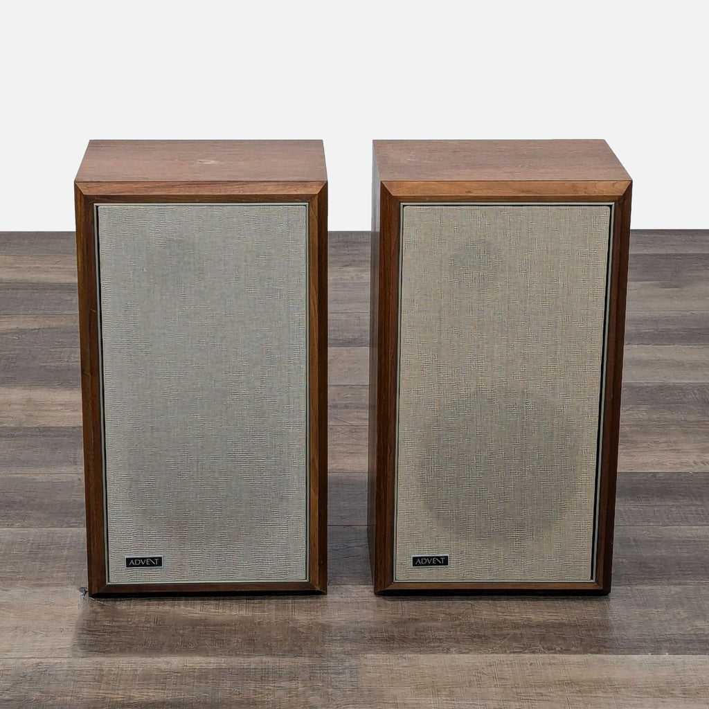 two black and white televisions sitting on a wooden table 
