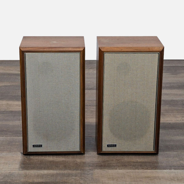 two black and white televisions sitting on a wooden table 