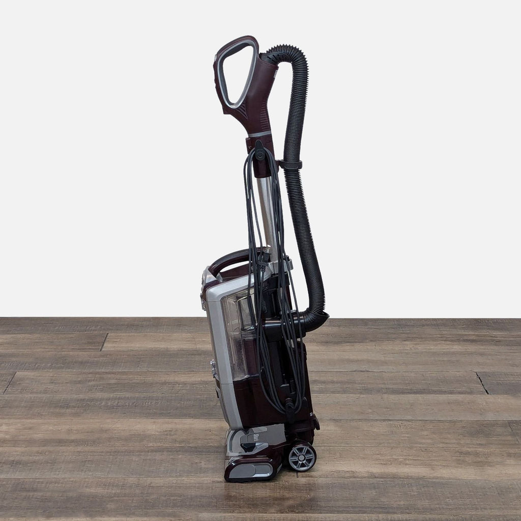a black and white vase with a tennis racket on a wooden floor 