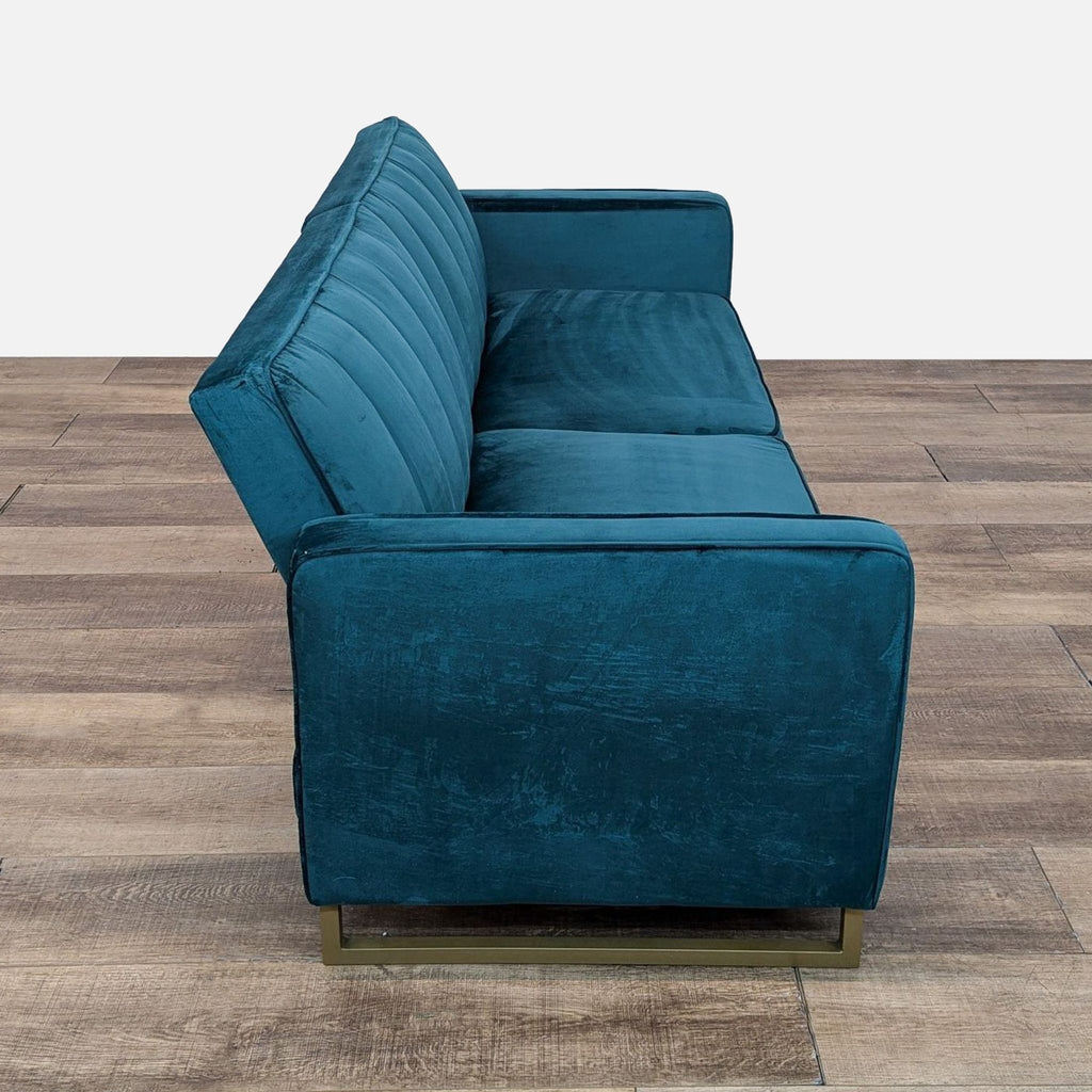 a blue couch sitting on top of a wooden floor 