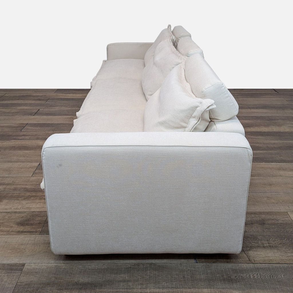 a white dog laying on a white couch 