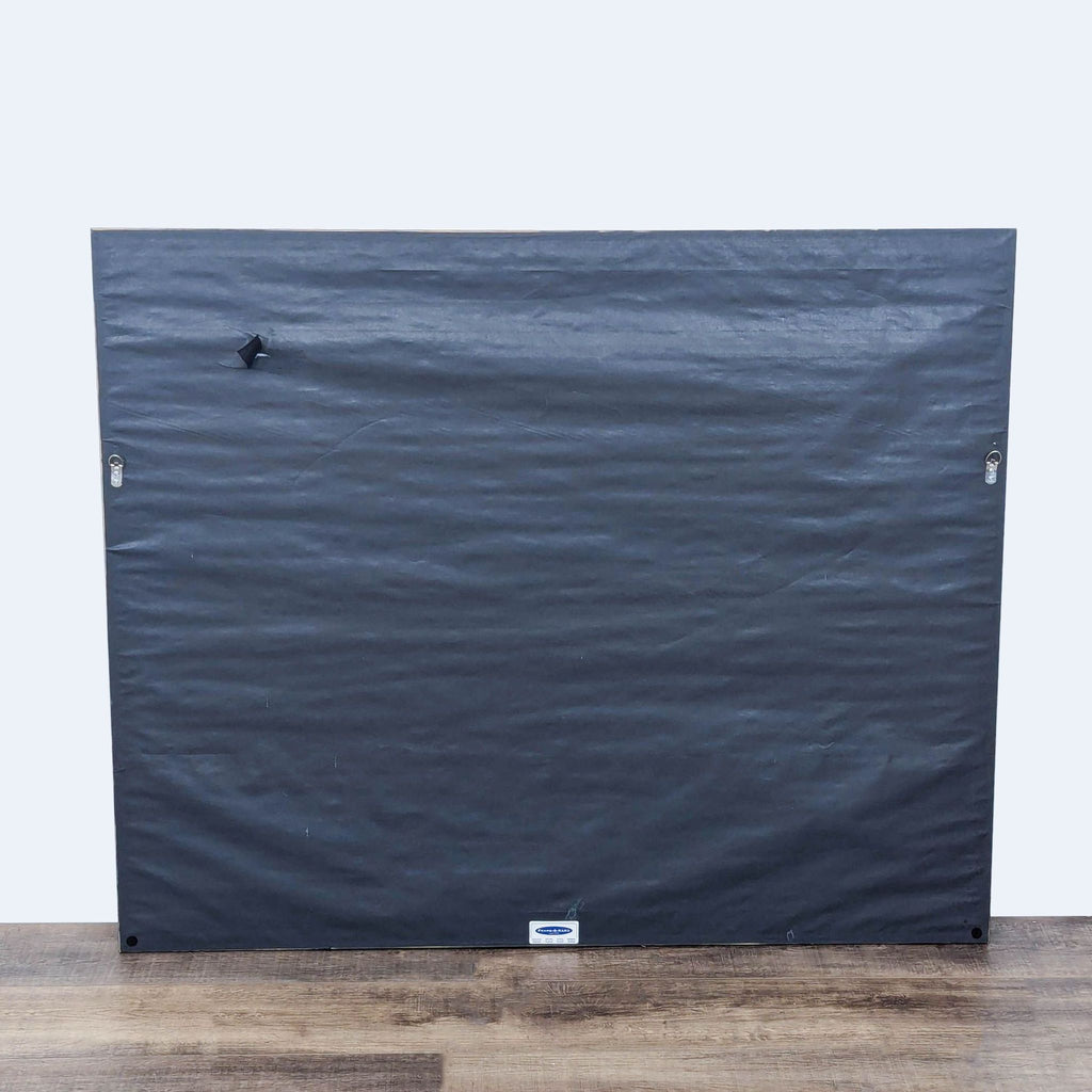 a box on a wooden floor with a piece of wood on top 