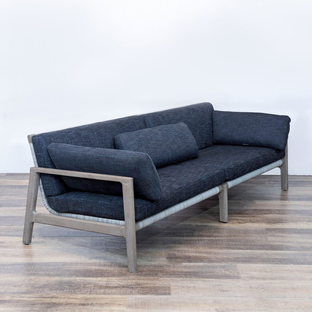 Outdoor Mesa sofa featuring architectural teak frame, woven wicker back, and cushioned seating.