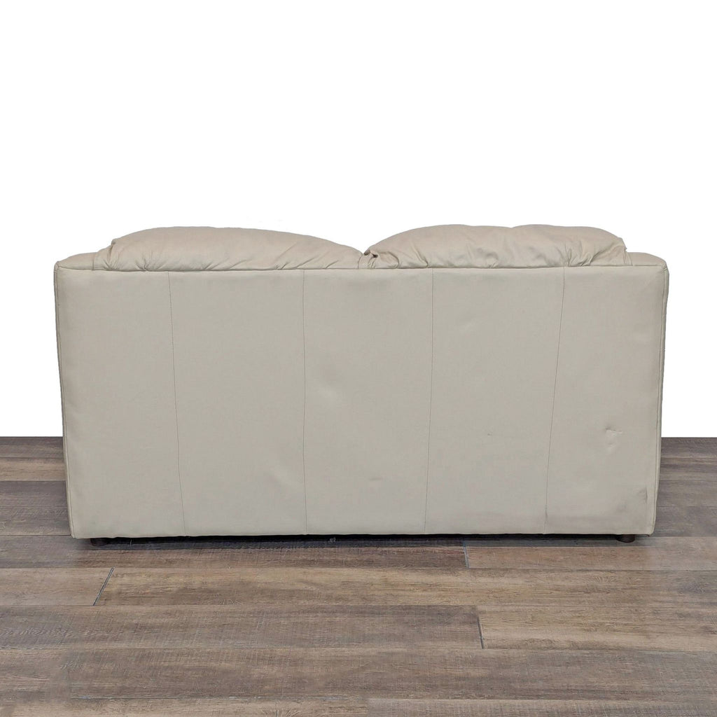 Back view of a beige leather loveseat with smooth leather finish.