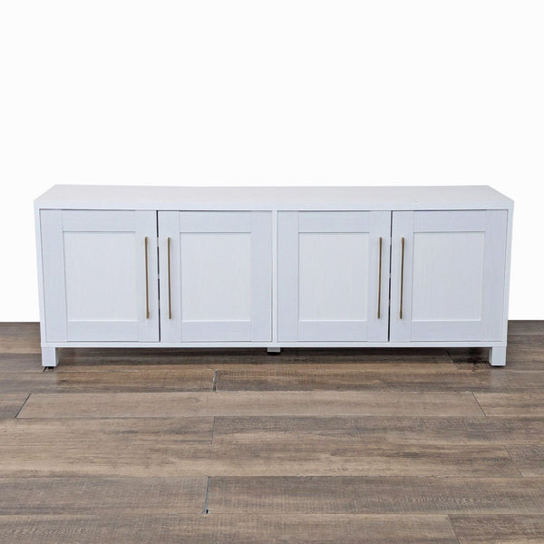 Sleek entertainment center with brass handles on wood floor.