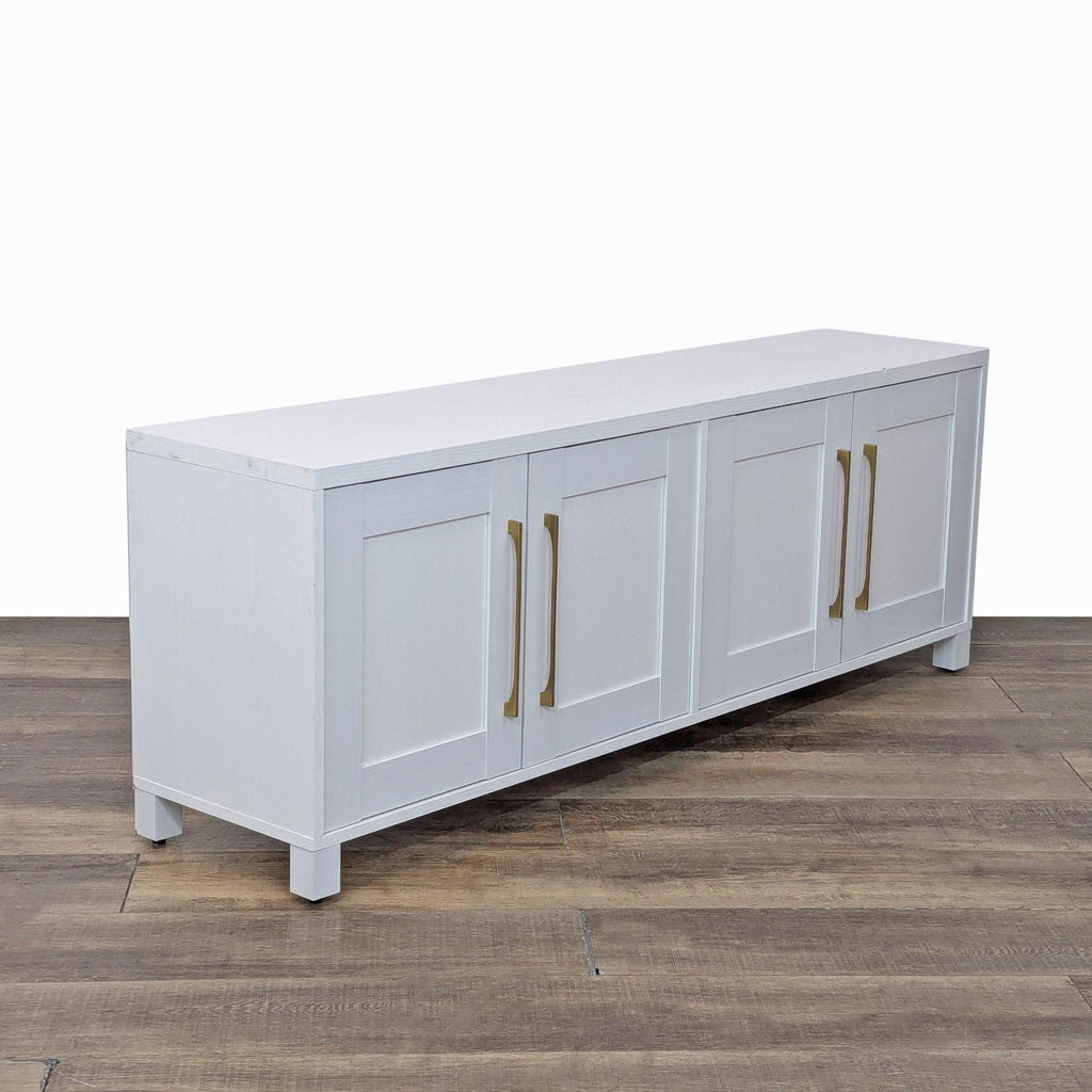 Side view of white entertainment unit with elegant brass handles.
