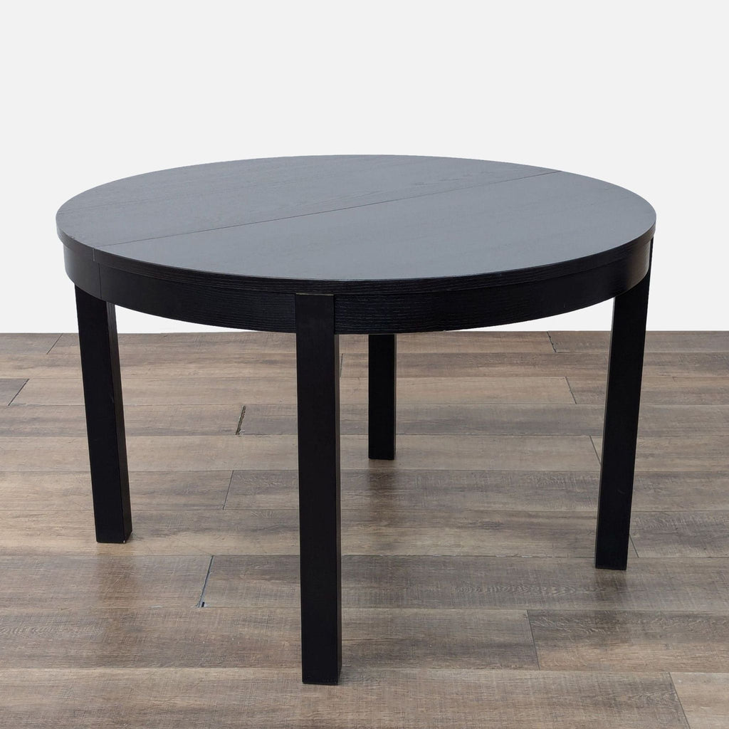Black wood dining table, extendable, with metal and wood chairs.