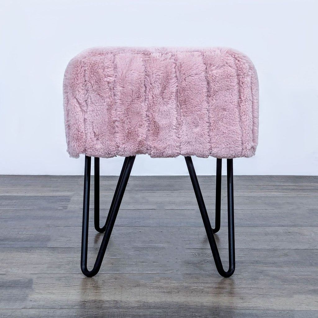 Side view of pink fur bench with metal legs, highlighting texture.