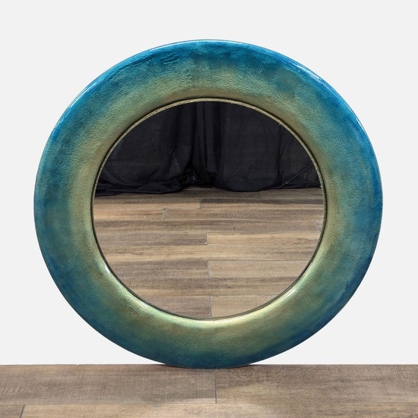 Round mirror with a textured, gradient blue and green frame from Reperch.