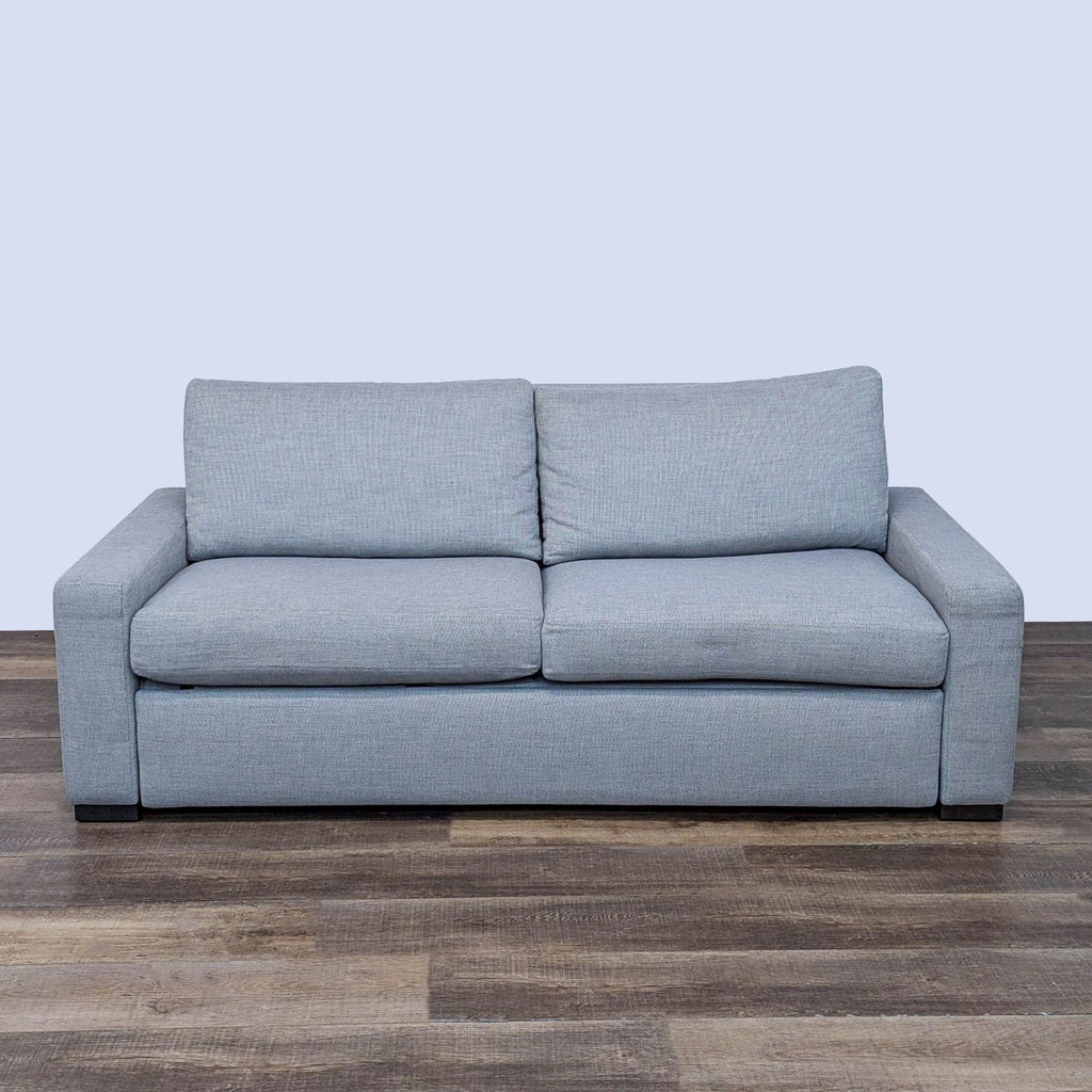 Modern gray sleeper sofa with plush cushions, crafted for durability and style.