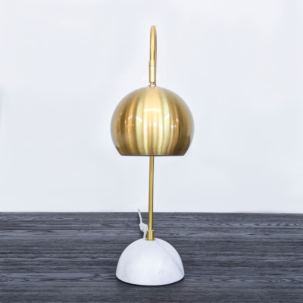 Contemporary lamp featuring brass and marble accents.