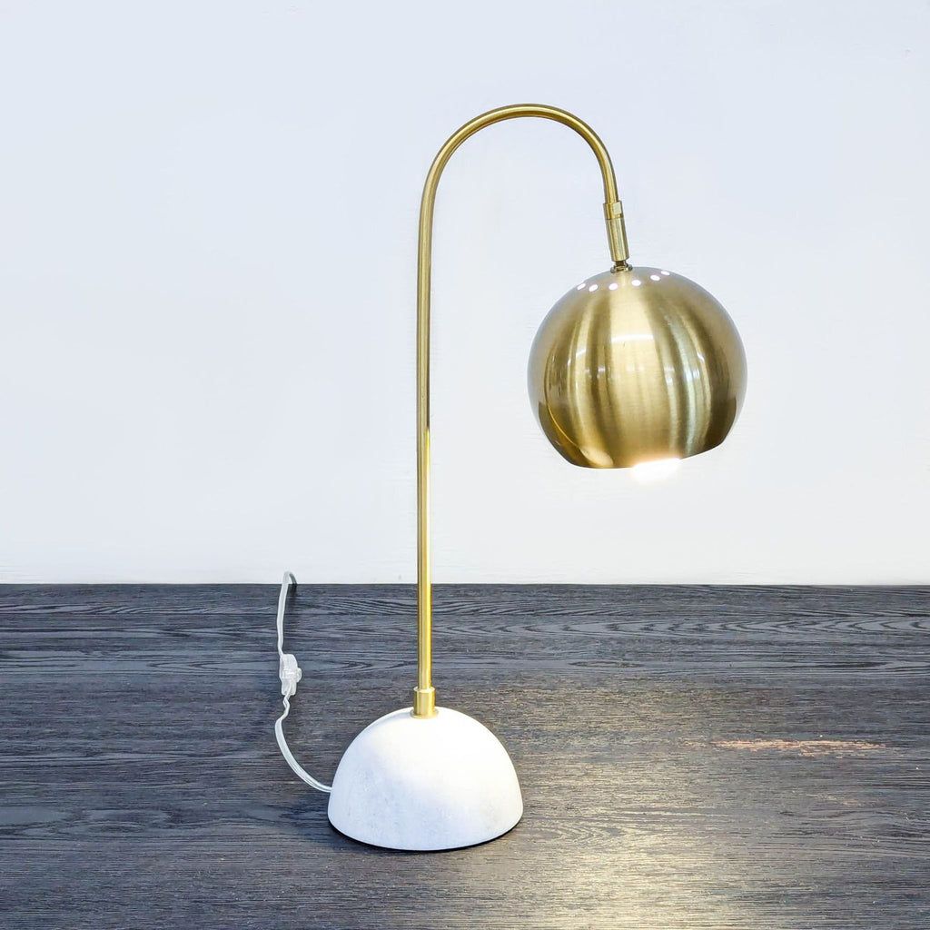 Elegant table lamp with arched brass design and marble base.