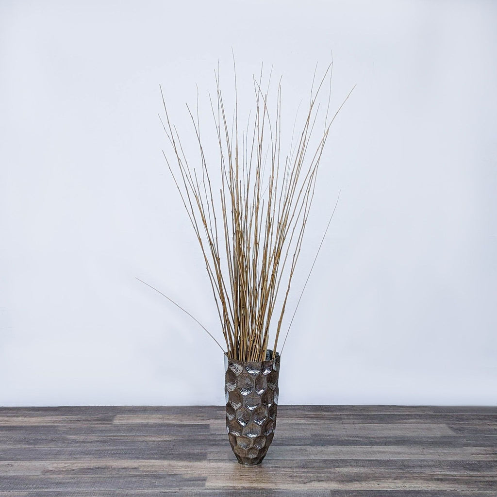 Reperch vase with tall decorative branches on a wooden surface.  