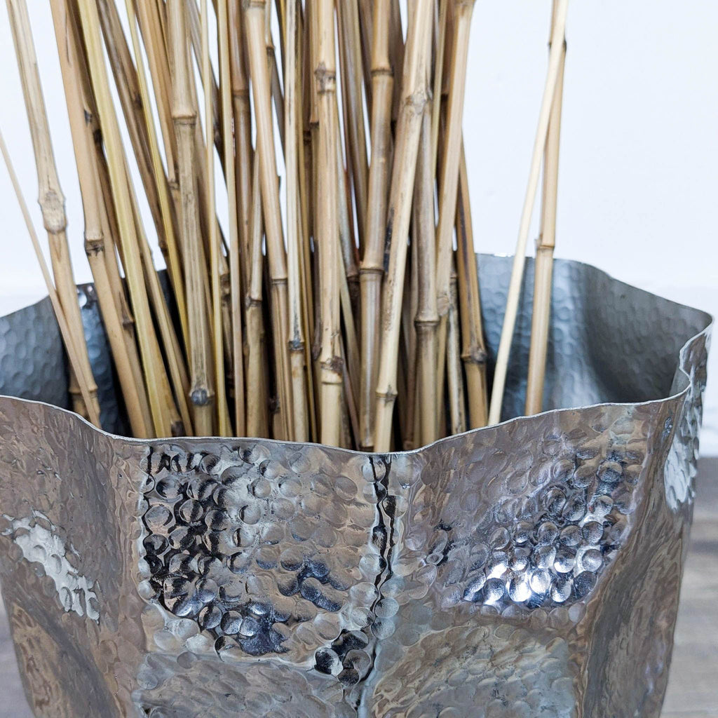 Close-up of Reperch vase showing textured metallic finish with branches.  