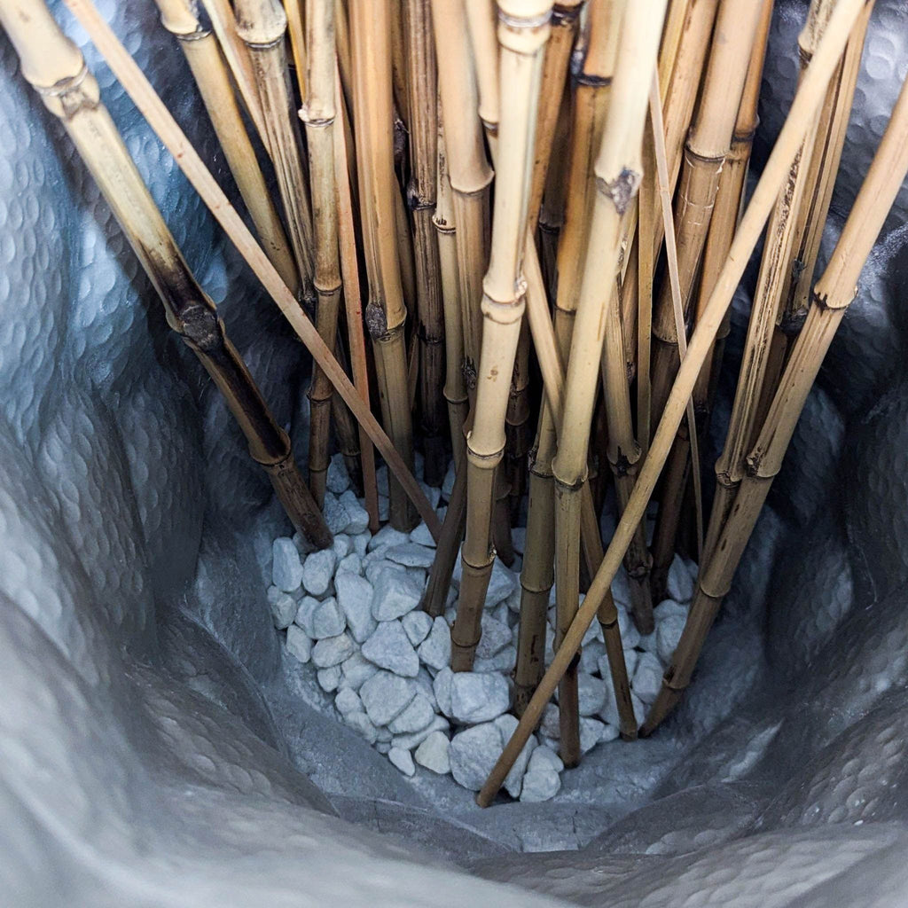 Inside Reperch vase filled with small white stones and branches.  