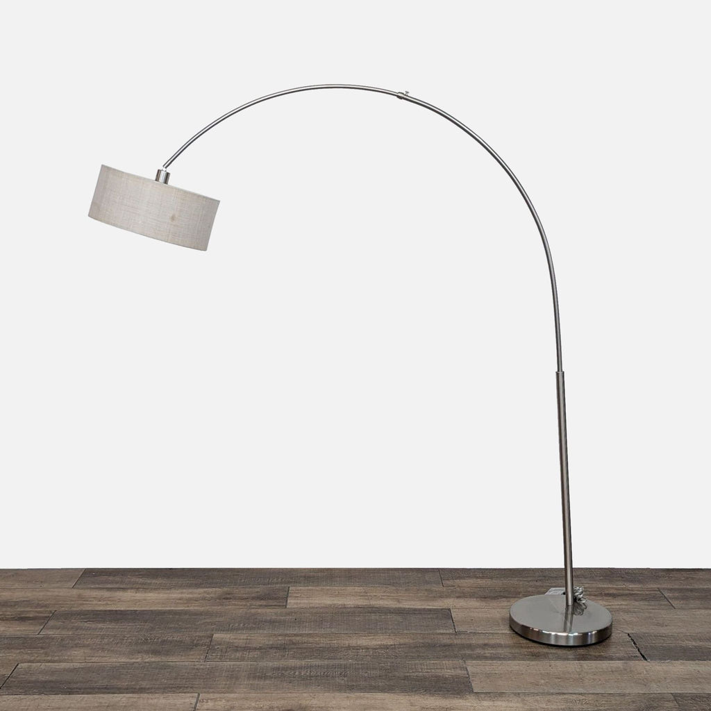 CB2 sweeping arc lamp with round base and fabric shade.
