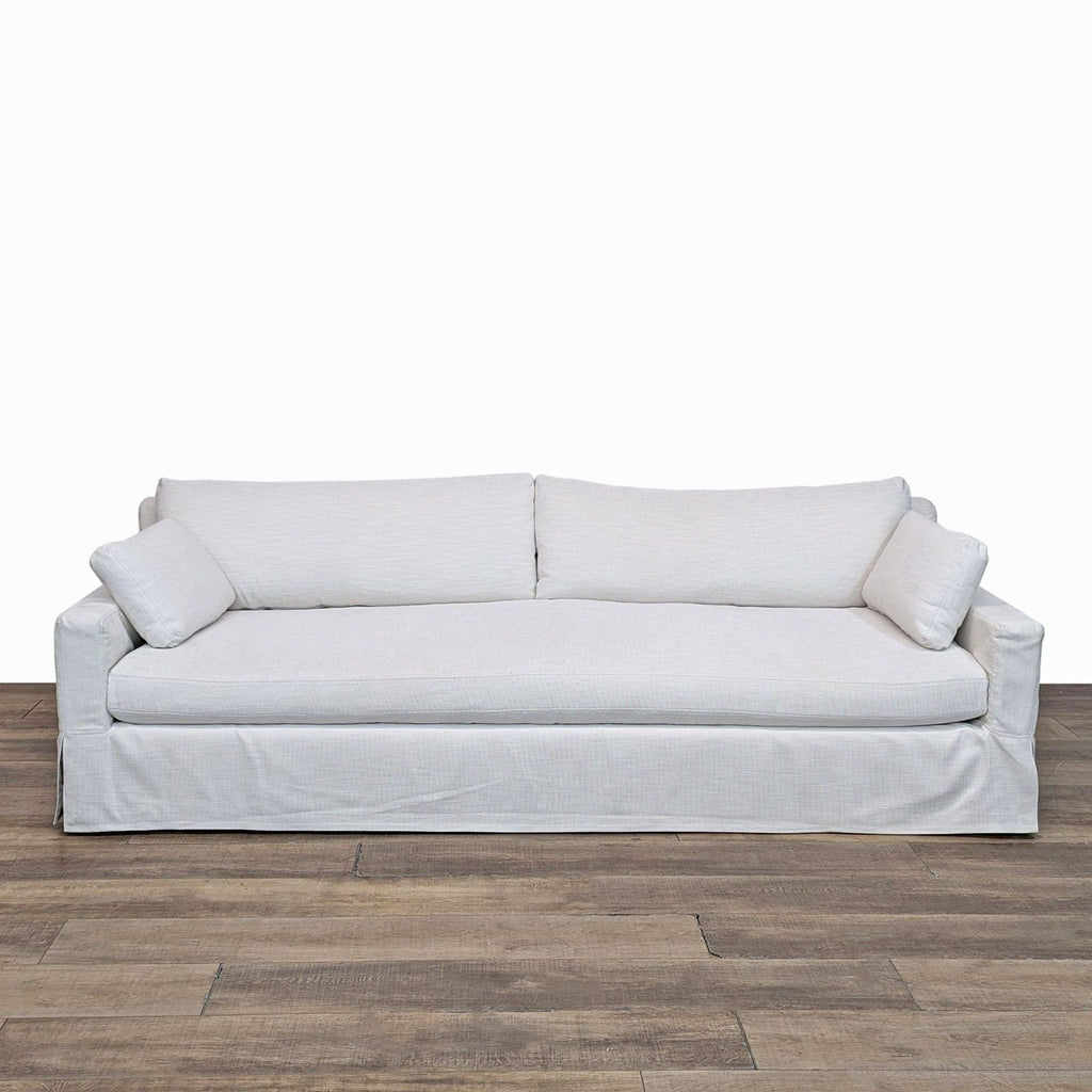 a white couch sitting on top of a wooden floor 