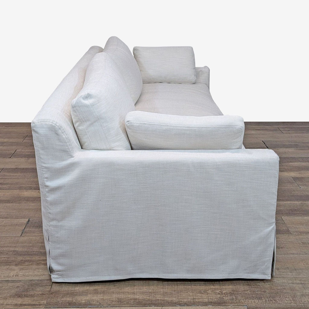 a white couch with a black chair on it 