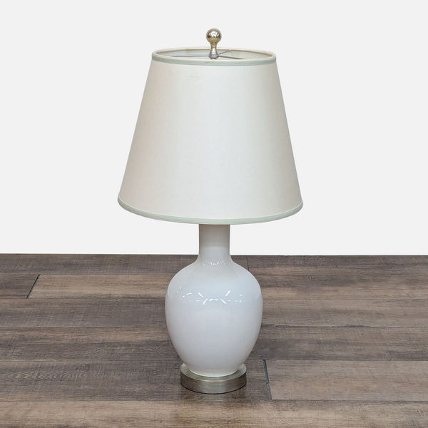 1. Reperch table lamp with white crackled glass base, antique silver footing, and classic fabric shade on wood floor.