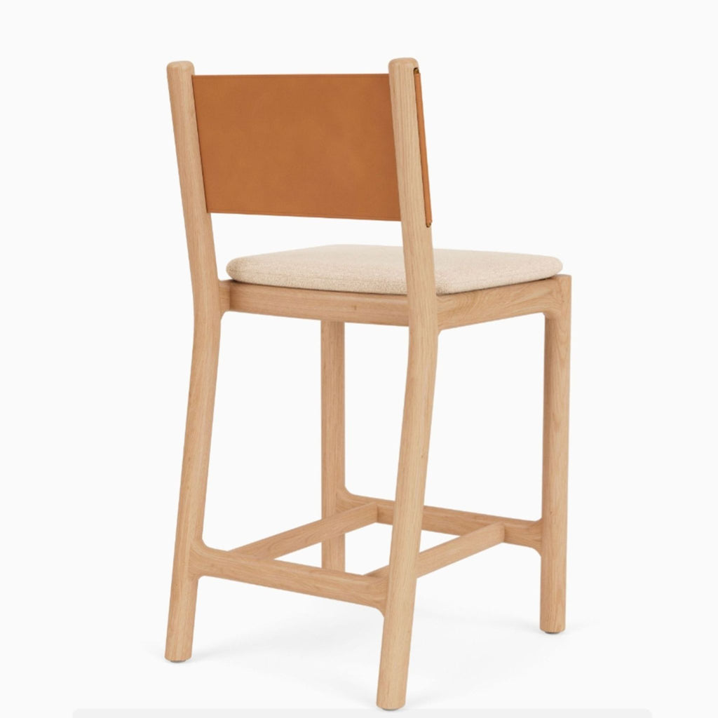 Wood-framed stool featuring a backrest in Italian leather, accented with brass pins and a washable seat pad.  
