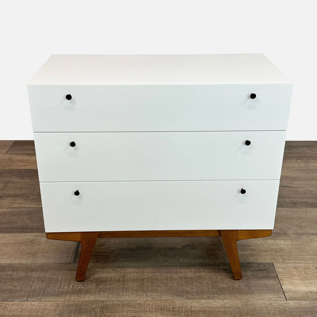 a white wooden cabinet with a black and white striped tie 