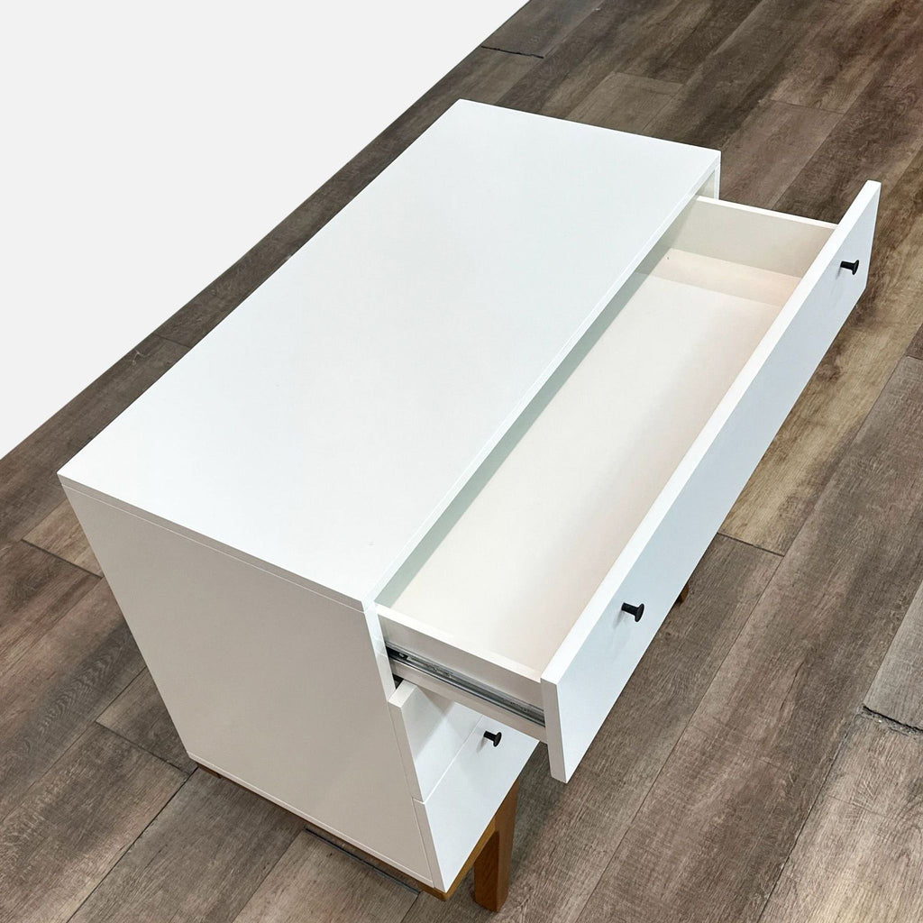 a white refrigerator sitting on top of a wooden floor 