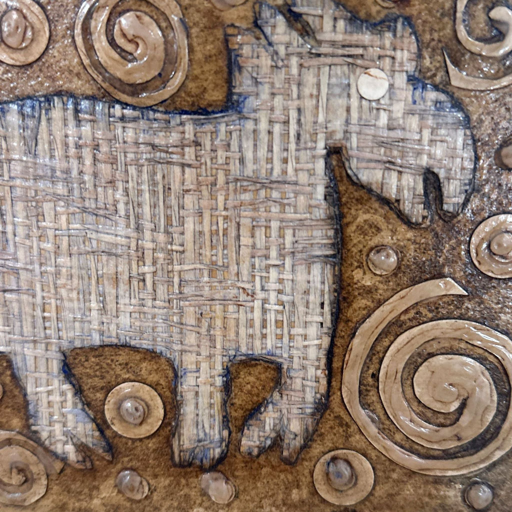 2. Close-up of the animal silhouette’s woven texture and spiral pattern details in Yvonne Browne’s rustic art piece.